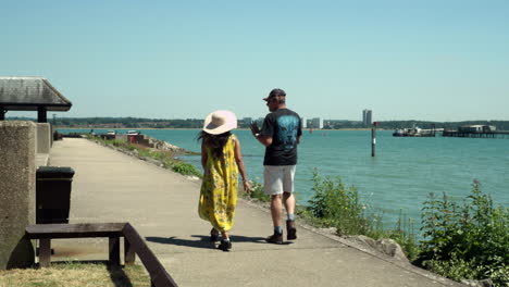 Una-Pareja-De-Turistas-Indios-Disfrutando-De-Un-Paseo-Por-El-Puerto-Deportivo-De-Hythe-Adyacente-A-Las-Aguas-De-Southampton,-Inglaterra,-Reino-Unido.