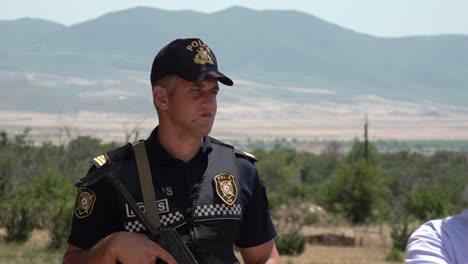 Die-Aserbaidschanische-Polizei-Bewacht-Mit-Einer-Ak47-Während-Einer-Tour-Durch-Agdam-In-Berg-Karabach,-Aserbaidschan