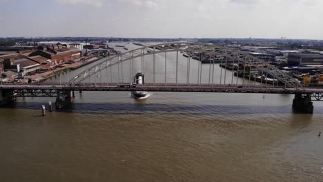 Tyda-Kyra-Inland-Motor-Freighter-Travelling-Under-Road-Bridge-On-River-Noord