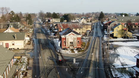 AERIAL-Following-Amish-Horse-And-Cart-Along-Town-Street-During-Snowfall