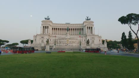 Slow-motion-of-bus-and-car-traffic-at-Piazza-Venezia-or-Venice-Square-with-Altare-Della-Patria-in-Rome-at-dusk,-Italy