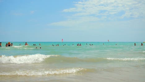 Escena-De-Verano-En-La-Playa-De-Alcossebre,-España-Con-Multitud-De-Personas-Nadando-En-El-Azul-Brillante-Del-Mar-Mediterráneo