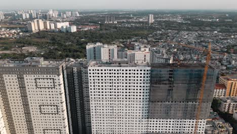 Drone-Volando-Hacia-Atrás-Con-La-Cámara-Inclinada-Hacia-Arriba-Muestra-Un-Edificio-En-Construcción-Con-Una-Línea-De-Cielo-Despejada