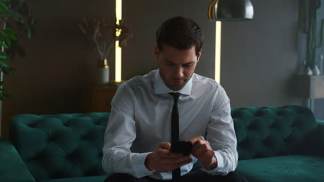 Business-man-typing-on-smartphone-at-office.-Surprised-manager-using-cellphone