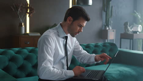 Businessman-working-on-laptop-indoors.-Male-manager-pointing-at-chart-on-screen
