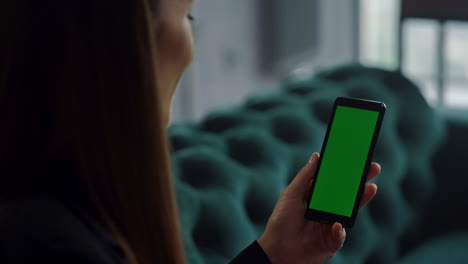 Businesswoman-waving-hand-at-green-screen-phone-in-office.