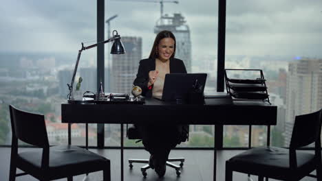 Businesswoman-reading-news-on-laptop-at-workplace.-Worker-celebrating-success