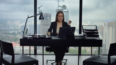 Businesswoman-video-chatting-on-laptop-at-workplace.-Woman-gesturing-at-camera