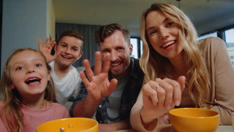 Parents,-kids-looking-camera-home.-Family-waving-hands-during-morning-video-call