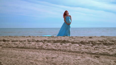 Mujer-Romántica-Con-Vestido-Azul-En-La-Playa.-Mujer-Embarazada,-Tenencia,-Vientre