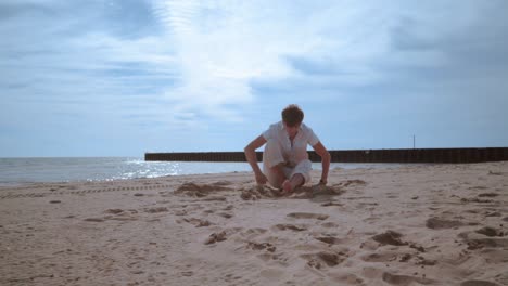 Man-lying-on-sand.-Man-stand-up-from-beach-and-go-out-of-frame
