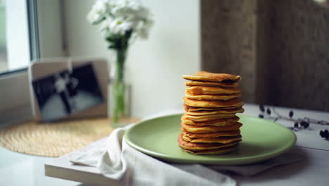 Man-hand-puts-piece-of-butter-on-stack-of-pancakes.-Pancake-breakfast
