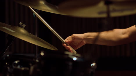 Closeup-man-hands-playing-on-percussion-instrument-in-recording-studio.