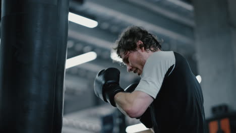 Candid-kickboxer-training-at-gym.-Focused-sportsman-boxing-in-sport-club