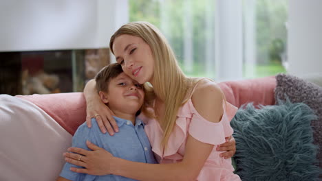 Cheerful-boy-hugging-mother.-Smiling-woman-embracing-son-at-home
