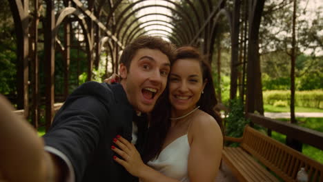 Sweet-bride-showing-tongue-on-camera-outdoors.-Couple-making-facial-expressions