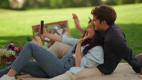 Happy-girl-and-guy-having-video-call-in-park.-Couple-sending-greetings-on-phone
