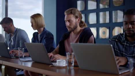 Multi-ethnic-business-people-working-with-laptop-computer-in-modern-office
