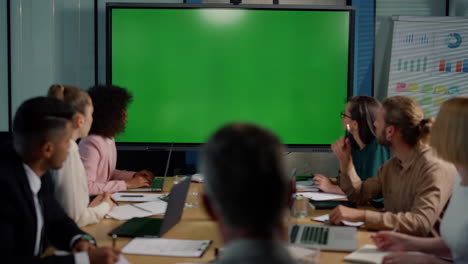 Team-looking-at-presentation-with-green-board.-People-having-video-conference