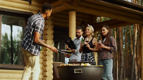 Cheerful-friends-having-rest-on-grill-party-outdoors.-Guys-clinking-glasses