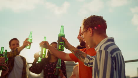 Multiracial-people-clinking-bottles-outdoors.-Happy-friends-drinking-beer.
