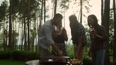 Relaxed-people-eating-french-beans-in-summer-forest.-Guys-tasting-bbq-vegetables