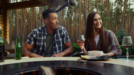 Smiling-guy-and-girl-having-rest-on-backyard.-Couple-speaking-with-friends
