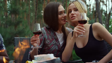 Beautiful-women-drinking-wine-outside.-Girlfriends-chatting-on-grill-party