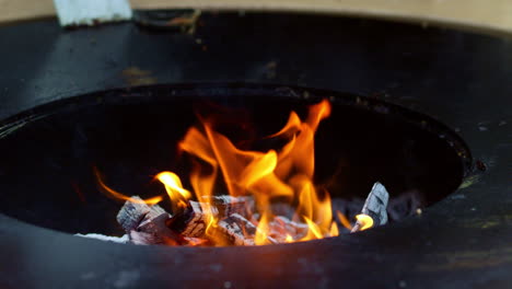 Spatula-outdoors.-Closeup-fire-from-grill-outside.-Unknown-man-cleaning-grill