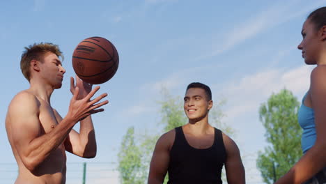 Three-mixed-race-players-training-street-basketball-in-sport-playground.