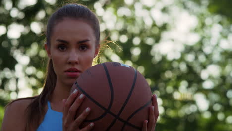 Portrait-of-focused-woman-player-playing-streetball-basketball-outdoors