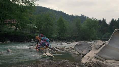 Hikers-touching-water-in-river.-Positive-couple-splashing-water-with-hands