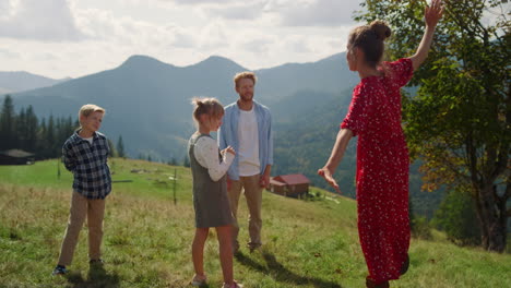 Parents-playing-funny-games-with-children-on-mountain-slope.-Mother-dancing.