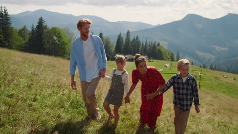 Happy-family-enjoying-walk-in-mountains.-Couple-with-kids-holding-hands-outdoor.