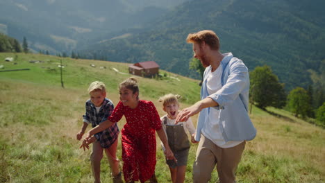 Parents-have-fun-children-on-mountain-hill.-Happy-family-walking-summer-day.