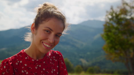 Closeup-smiling-woman-posing-in-front-mountains.-Portrait-happy-girl-on-nature.