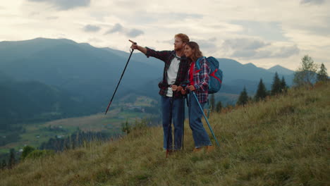 Two-tourists-talk-outdoors-on-mountains-hike.-Travelers-couple-trekking-nature.