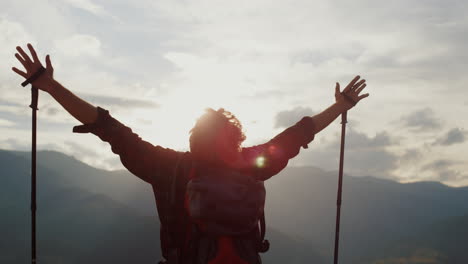 Joyful-hiker-raise-hands-to-mountains-sky.-Tourist-celebrate-freedom-close-up.