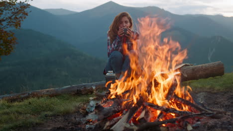 Closeup-relaxed-woman-camping-on-nature.-Tourist-look-bonfire-in-mountains-trip.