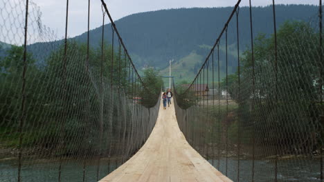 Touristen-Laufen-über-Eine-Flussbrücke-In-Den-Bergen.-Wanderer-Haben-Gemeinsam-Spaß-In-Der-Natur