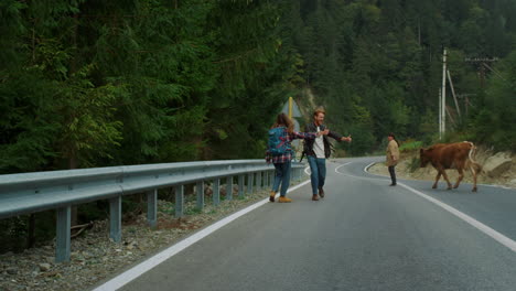 Hitchhikers-trekking-mountains-highway-at-summer.-Couple-catch-car-on-roadside.