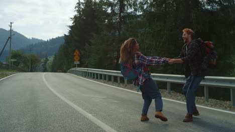 Lovers-dancing-around-forest-nature-on-mountains-road.-Couple-hold-hands-outside