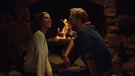 Happy-couple-enjoy-evening-romantic-date.-Lovers-laugh-together-by-fireplace.