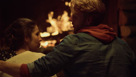 Caring-couple-talk-date-on-romantic-night.-Boyfriend-girlfriend-enjoy-fireplace.