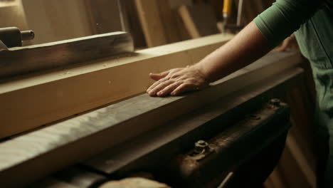 Man-preparing-wooden-plank-for-product-indoors.-Carpenter-working-on-wood-lathe