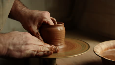 Artist-sculpting-clay-product-in-pottery.-Man-producing-new-product-in-workshop