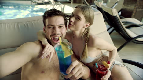 Makro-Eines-Schönen-Paares,-Das-Ein-Selfie-In-Der-Nähe-Des-Pools-Mit-Cocktails-Macht.