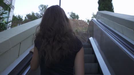 Woman-moving-up-on-escalator.-Slow-motion-beautiful-girl-climbing-the-escalator