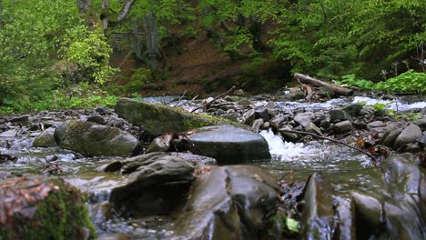 Riesige-Steine-Inmitten-Eines-Schnellen-Gebirgsflusses.-Wilder-Waldflusshintergrund