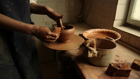 Unrecognized-artist-sculpting-on-potters-wheel.-Woman-making-handmade-pot